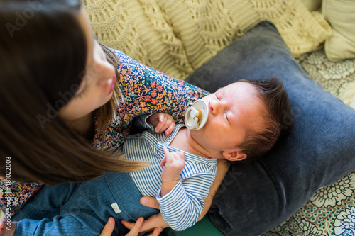 Overhead view of big sister holding hew newborn baby brother.