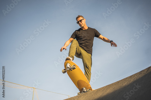 Serious adult man prepared to go down with Skate Surf on a ramp