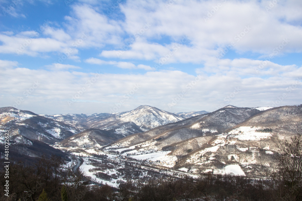 View of the mountain on a beautiful sunny winter day. The sky is blue, and the snow has covered the trees and fields. View of the mountain on a beautiful sunny winter day. The sky is blue, and the snow has covered the trees and fields.