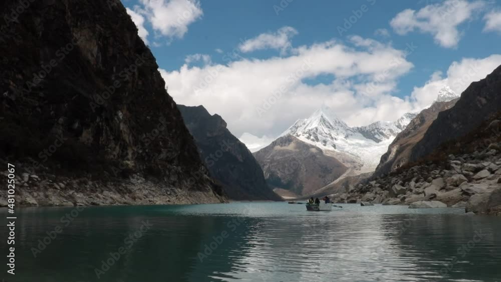 Boat paddles in the mountain lake Paron with its turquoise waters in the high Andes of Peru Boat paddles in the mountain lake Paron with its turquoise waters in the high Andes of Peru