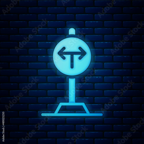 Glowing neon Fork in the road icon isolated on brick wall background. Vector