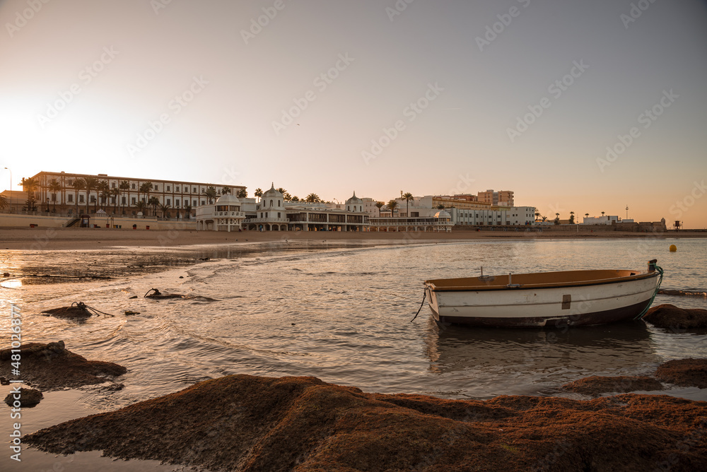 Boats docked in La Caleta beach at low tide at sunrise, Cadiz, Andalusia, Spain