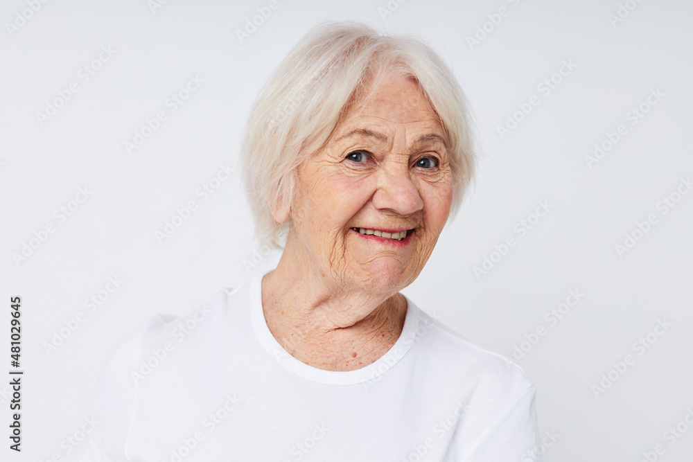 close-up of a cheerful elderly woman in a white t-shirt close-up of a cheerful elderly woman in a white t-shirt