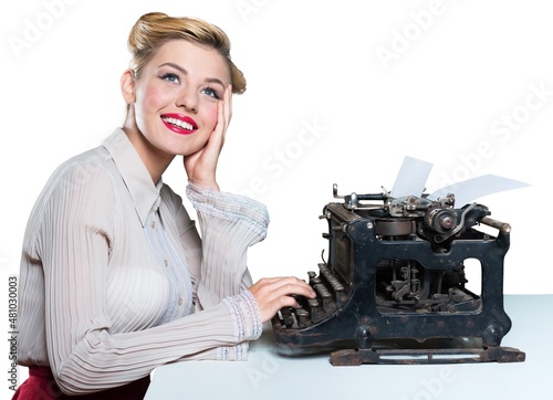 Retro woman working in office with vintage typewriter and phone, dressed in pin-up style photo