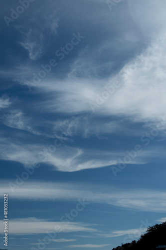  A Vibrant atmospheric cloudy sky cloudscape with white coloured wispy cirrus cloud formation in a mid blue sky.