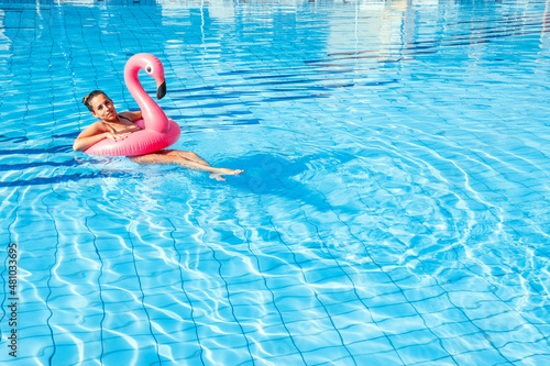 Young women pool. Happy young sexy girl in bikini swimsuit with pink inflatable flamingo float in blue water. Travel holidays vacation. Beauty  wellness  lifestyle.