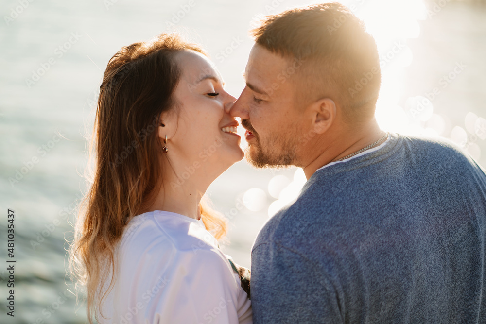 profiles couple in love kissing on the sea beach. solar glare profiles couple in love kissing on the sea beach. solar glare