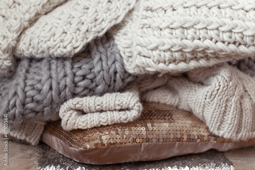 Close up of neatly folded knitted items of pastel color.