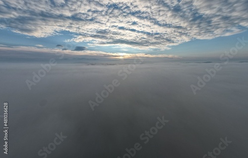 Between the clouds- hills getting from inversion layer on the ground and other layer of high altitude atmospheric clouds,stunning aerial panorama landscape view photo