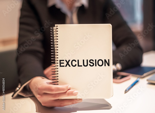 Canvas Print Woman at her working place holds the notebook with the text EXCLUSION