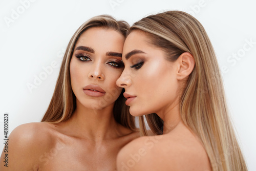 Fotografia, Obraz Beauty portrait of two beautiful young women with glowing glamour makeup and long straight hair