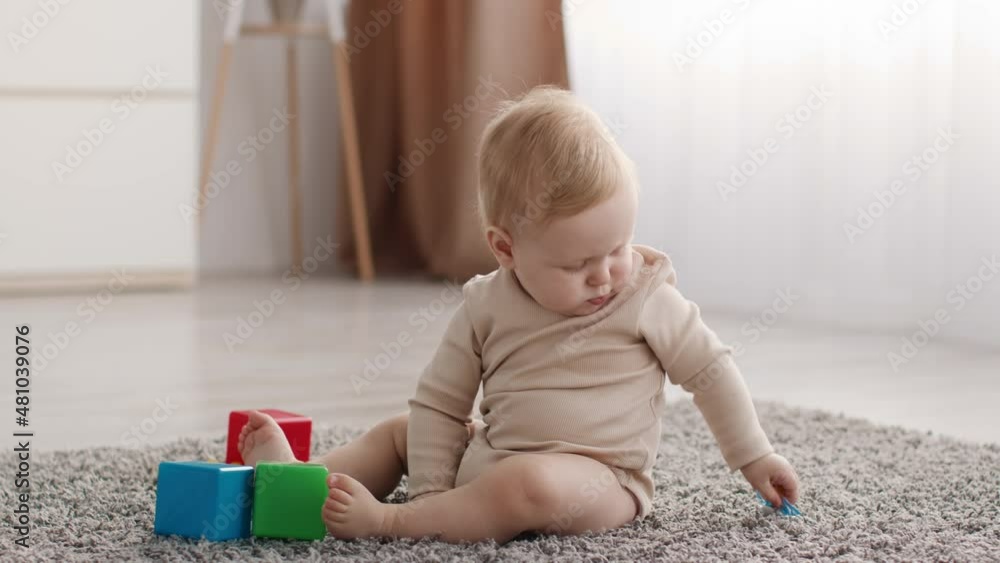 Cute Baby Playing With Pacifier While Sitting On Floor In Living Room Cute Baby Playing With Pacifier While Sitting On Floor In Living Room