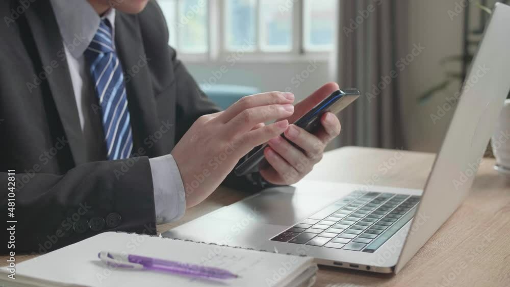 Close Up Of Asian Businessman Wearing Business Suit Using Mobile Phone After Using Computer For Working At Home.
Close Up Of Asian Businessman Wearing Business Suit Using Mobile Phone After Using Computer For Working At Home.