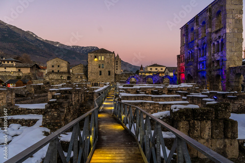 Aosta, roman teatre with snow at sunset. Remains of the Roman theater, built in 25 BC. covered with snow during the Christmas holidays photo