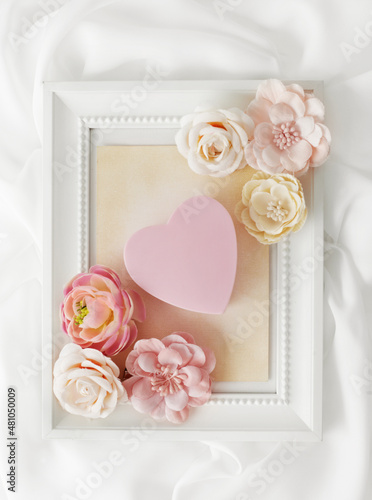 Valentines day or wedding card with pink heart and flowers in photo frame
