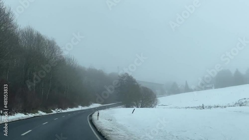 thr road in the magical fog. snow covered road to Wasserkuppe in Rhoen Hesse Germany. cars in the snow.  mystical landscape under the fog, the fog creates an illusion photo