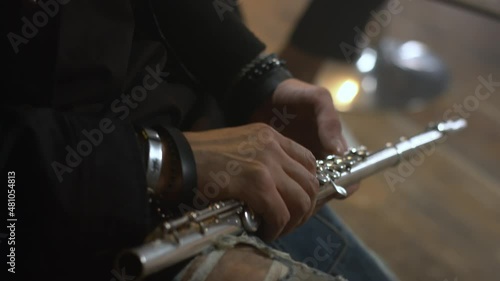 Male hands hold a flute. The musician plays in the orchestra. Classical music in live performance photo