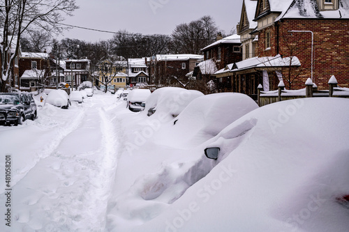  As a blizzard sweeps into a residential neighbourhood the streets fill with snow and residents start to shovel out their cars and sidewalks. Shot in the Toronto’s Beaches in January. Room for text.