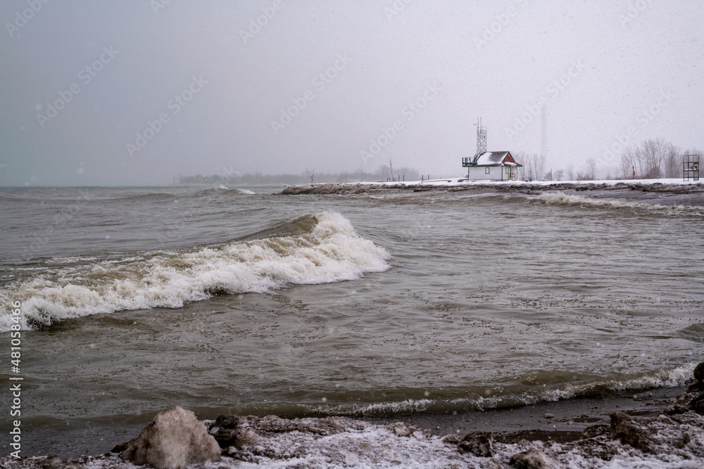 Waves crash on a beach during a blizzard with a lifeguard station in the background.  Shot in Toronto's Beaches neighbourhood.  Space for text.