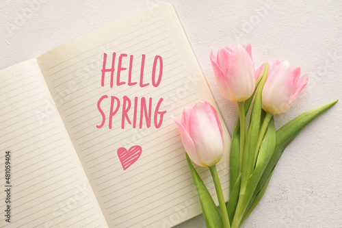 Notebook with text HELLO SPRING and tulip flowers on light background