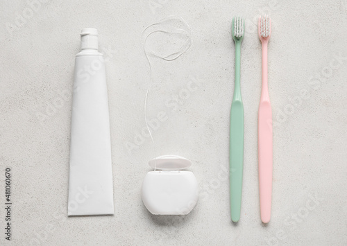 Fotografie, Obraz Dental floss with tooth brushes and paste on white background