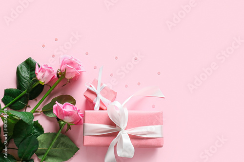 Presents for Valentine day, bouquet of roses and sequins on color background © Pixel-Shot