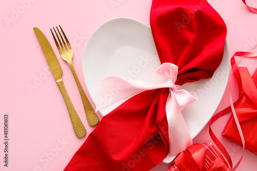 Beautiful table setting for Valentine's Day and gift boxes on pink background