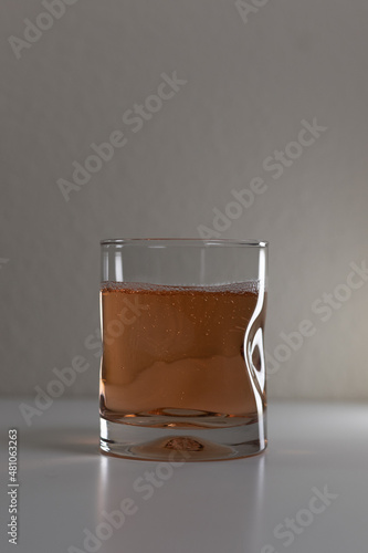 Fotografie Simple clear glass with bubbly liquid on a white background