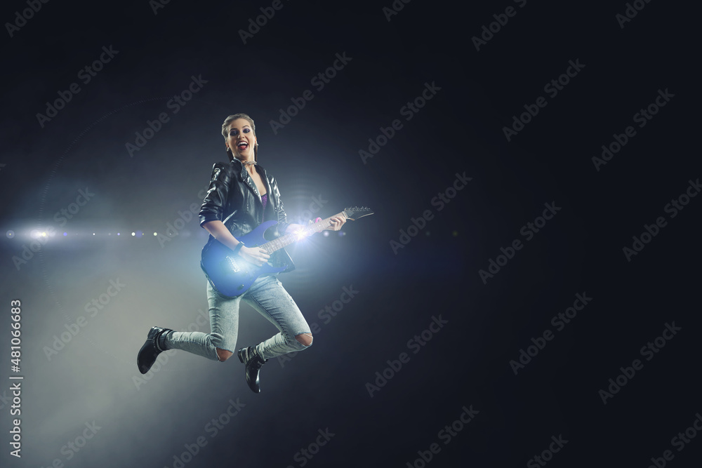 Young and beautiful rock girl playing the electric guitar