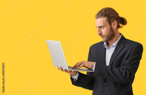Man with laptop on color ba...