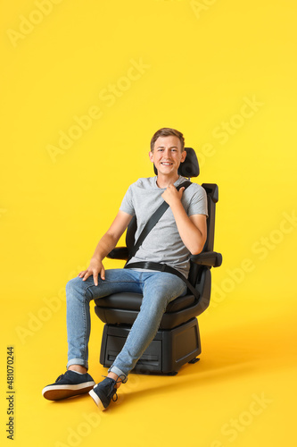 Man in car seat on color ba...