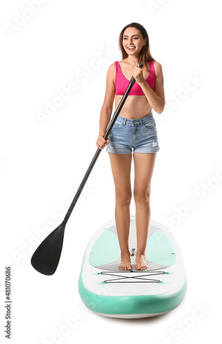 Beautiful young woman with board for sup surfing and oar on white background