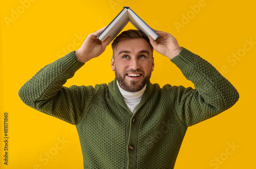 Happy young man with book o...