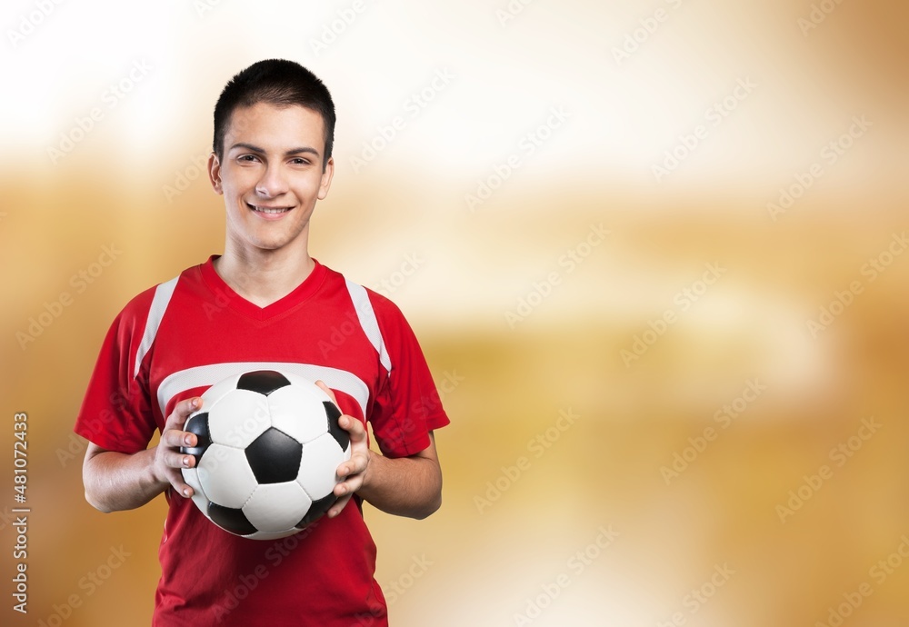 Cheerful school boy holding soccer ball and smiling at camera, playing football,