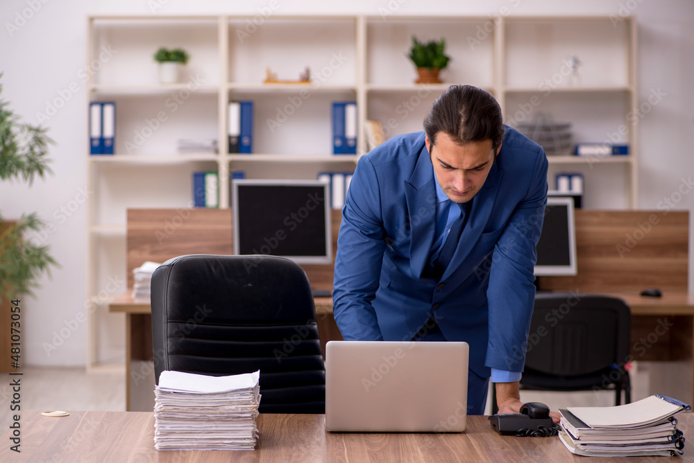 Young male employee and a lot of work in the office Young male employee and a lot of work in the office