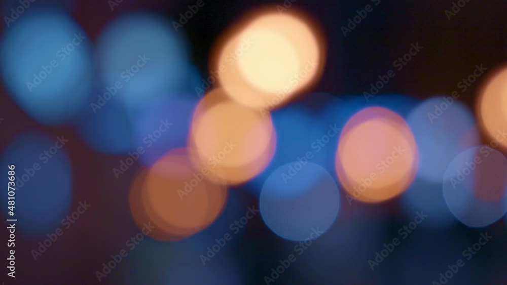 Abstract defocused bokeh lights background of people passing on the city street at night. Abstract defocused bokeh lights background of people passing on the city street at night.
