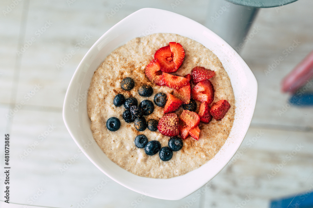 Homemade oatmeal with blueberries and strawberries in a bowl. Healthy breakfast. Top view Homemade oatmeal with blueberries and strawberries in a bowl. Healthy breakfast. Top view