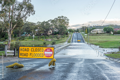 Flooded country road with 'closed road' sign (ID: 481074047)