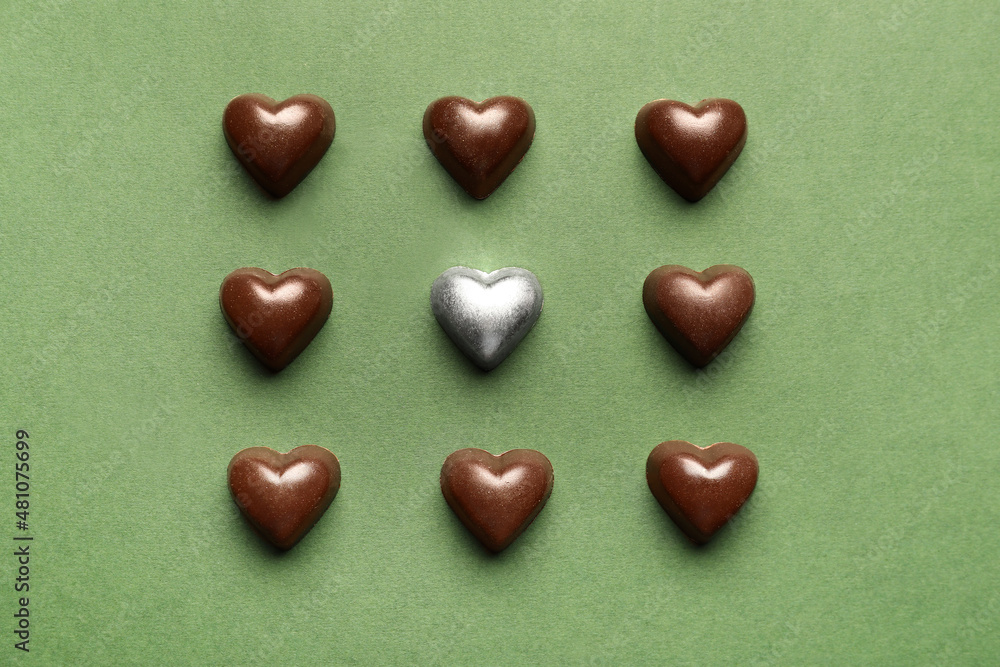 Obraz premium Tasty heart-shaped candies on green background