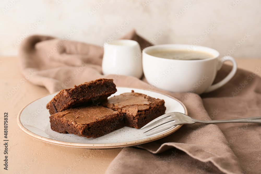Plate with pieces of tasty chocolate brownie on beige background Plate with pieces of tasty chocolate brownie on beige background