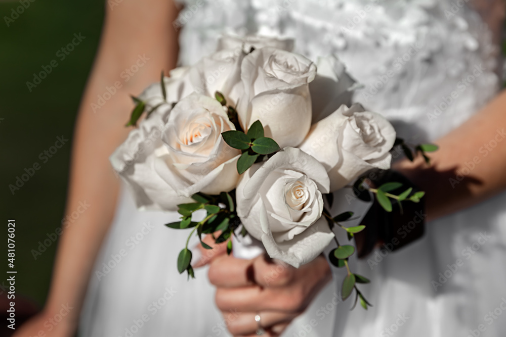 Bride holding wedding bouquet, flowers of white roses Bride holding wedding bouquet, flowers of white roses