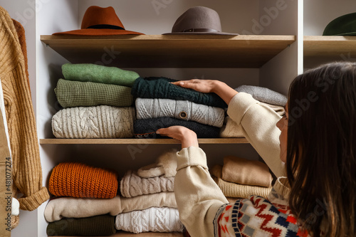 Woman taking warm sweaters ...