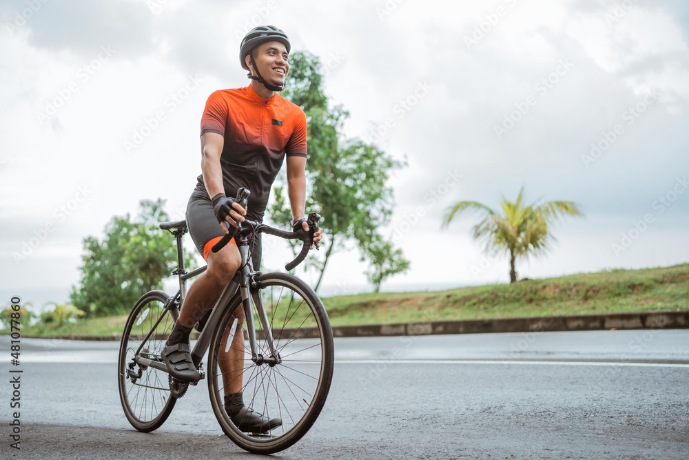 Fototapeta premium happy smiling road bike cyclist while riding his bike outdoor