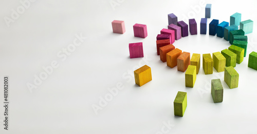 Gathering, centralization of data and people, concept image. Circle of colorful wooden blocks representing unity of diverse elements, on left side. Isolated on neutral white.