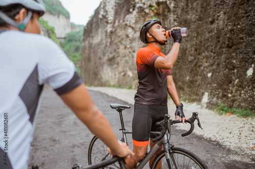 road bike cyclist take a brake and drink a bottle of water © Odua Images
