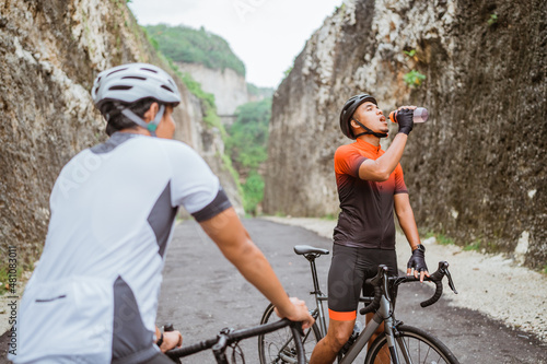 road bike cyclist take a brake and drink a bottle of water