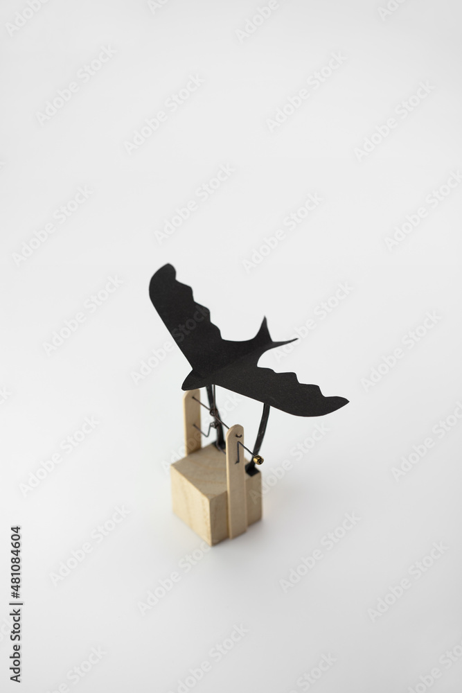 Flying bird automata or gadget with flying black bird. Isolated on neutral  white. Stock Photo | Adobe Stock