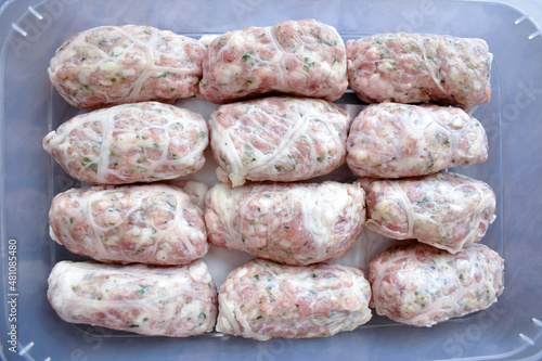 Traditional Cypriot food. Sheftalia : Cypriot Lamb and Pork Sausages. Raw sausages in a plastic box container. Selective focus. photo