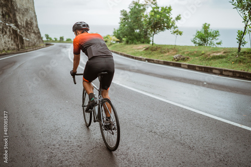 Fototapeta Naklejka Na Ścianę i Meble -  male cyclist riding his bike in country side shoot from the back