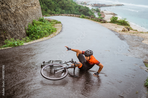 Foto Exhausted cyclist fell down on the road